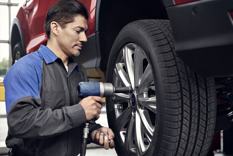 A service expert working on a car tire