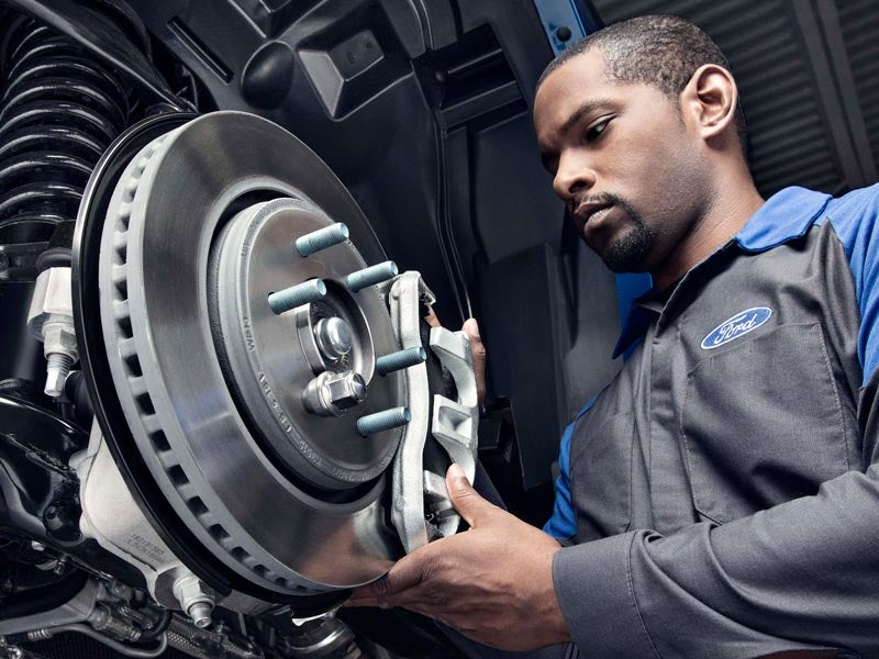 Ford service technician working on car brakes
