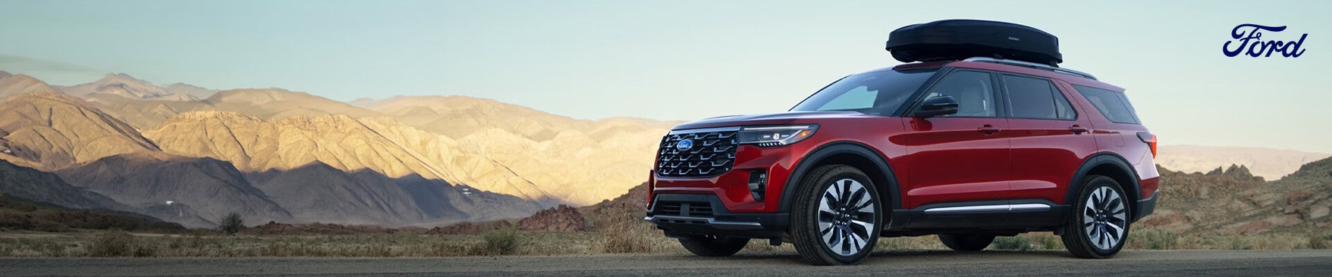 Red Ford Explorer pictured in a rugged desert landscape with Ford logo displayed